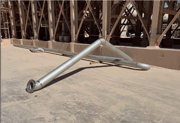 Stainless steel industrial piping system with flange awaiting installation in a food processing facility.