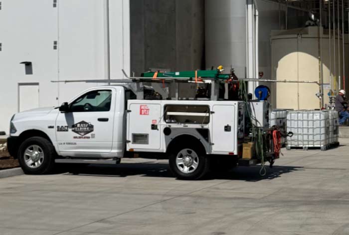 A white RAW Welding Inc. mobile service truck equipped with a professional welding rig and tools parked at an industrial job site