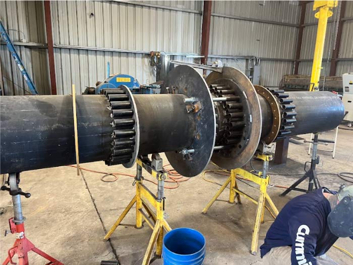 Industrial pressure vessel being repaired or altered with new tubing and flanges by a certified R-stamp team.