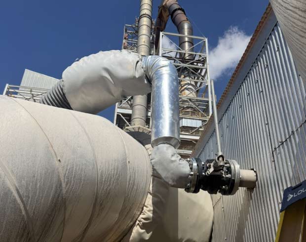 High-angle view of industrial piping systems and ventilation ducting at a facility requiring R-Stamp compliance and maintenance.